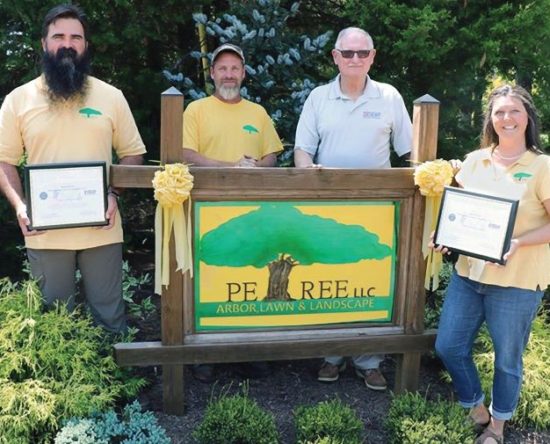 Group posing with plaque
