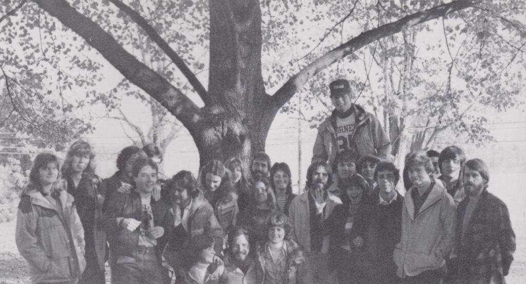 black and white photo a group of people under a tree