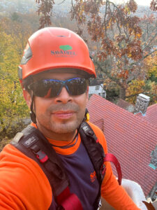 Man in orange shirt with helmet and sun glasses.