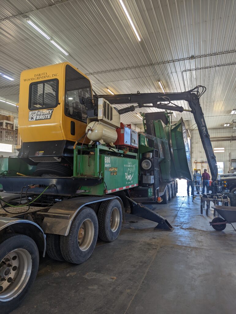 A used green and yellow large equipment in a garage