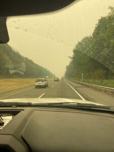 Looking at heavy smoke on a highway from inside of a car