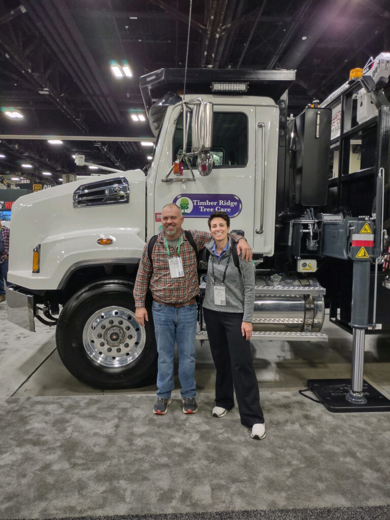 two people standing in front of white truck