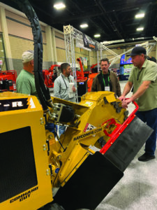 four people looking at yellow equipment