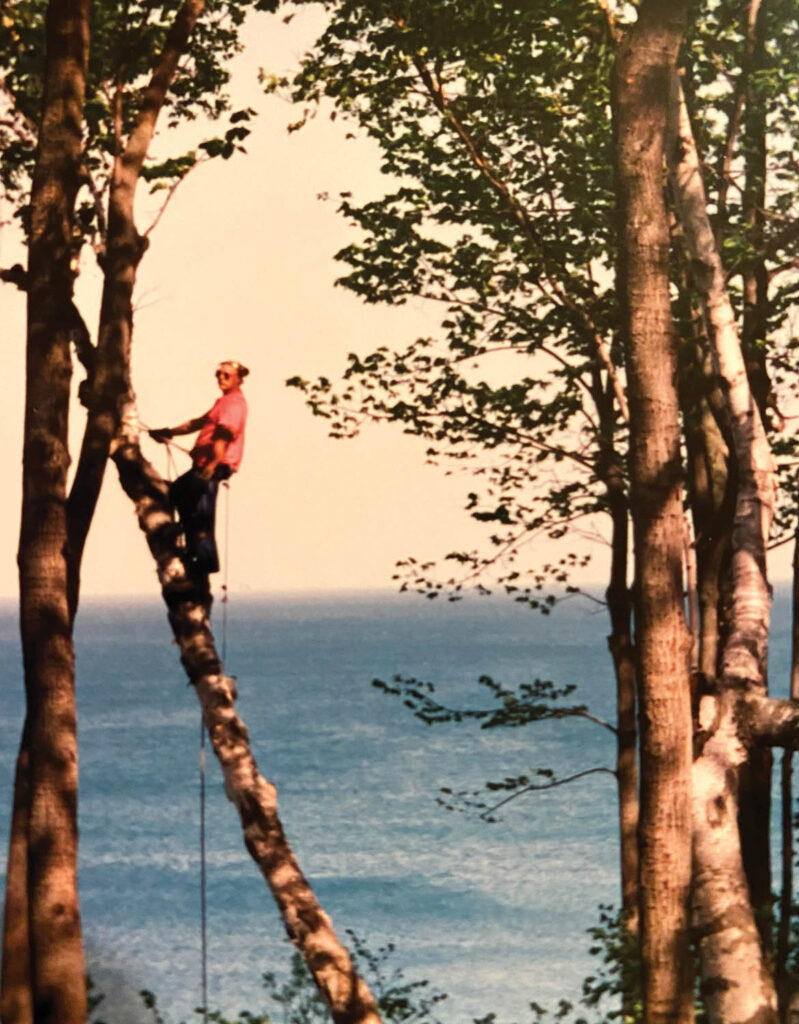 Dad climbing with Lake Michigan in the background.