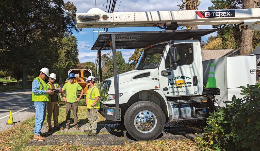 A Tennett Tree Service crew conducts an on-site job review prior to the start of work.